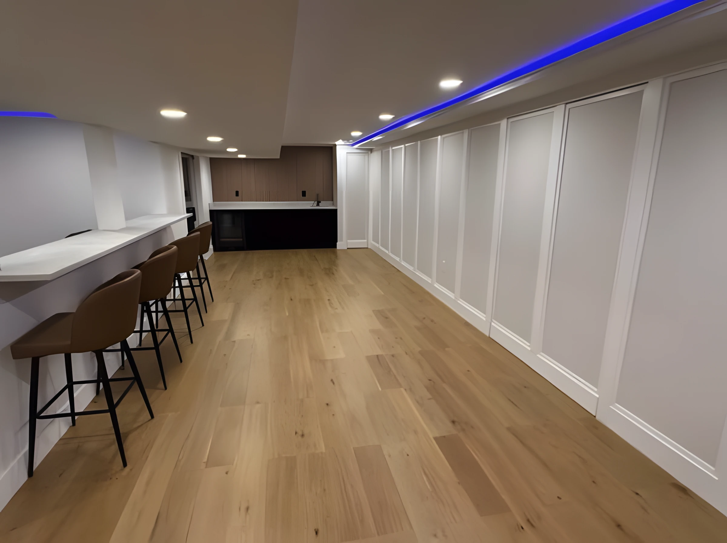 Finished basement with a wet bar, counter seating, wide-plank wood floors, wall paneling, and LED cove lighting