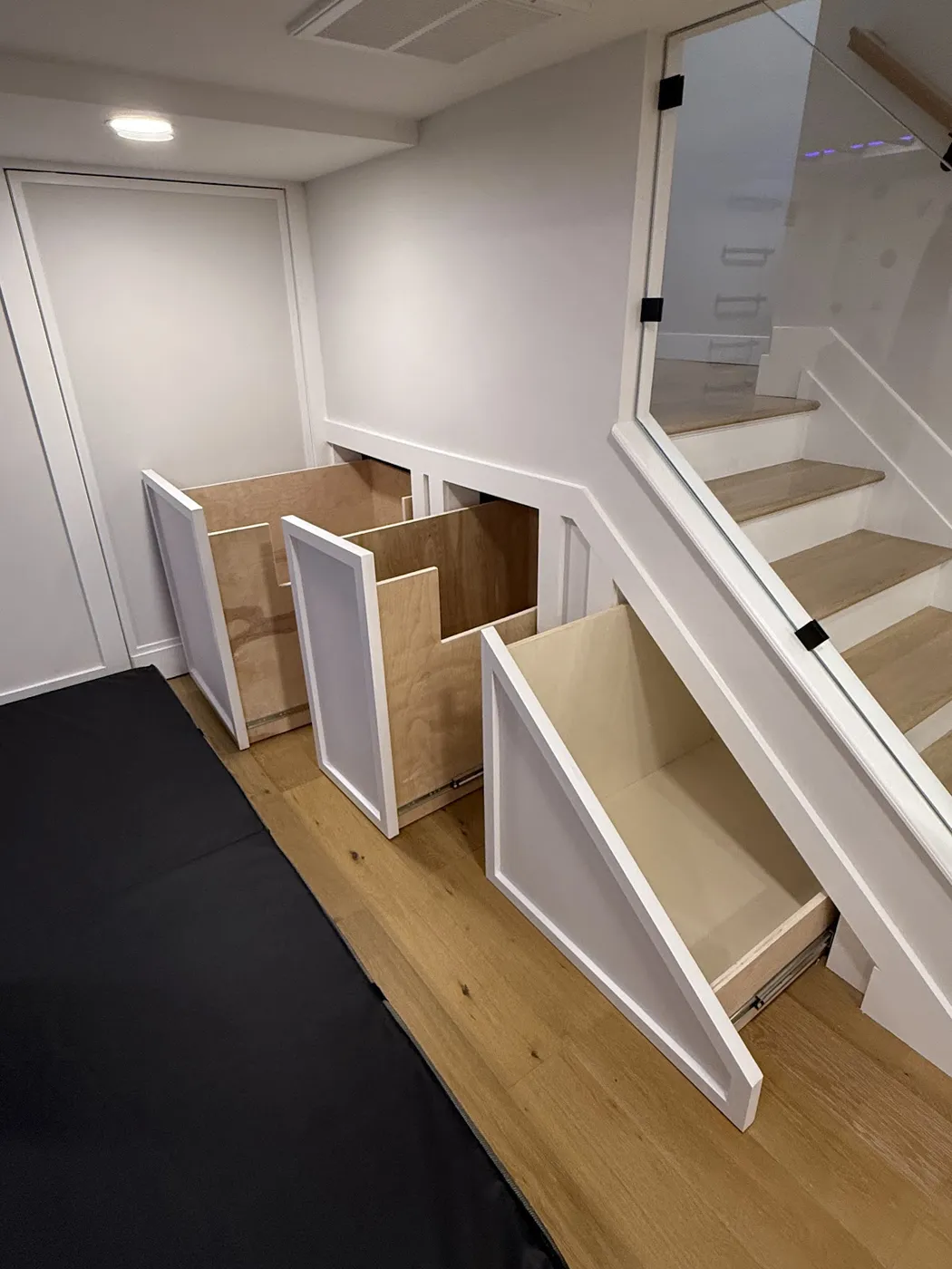 Basement staircase with pull-out storage drawers built into the space under the steps