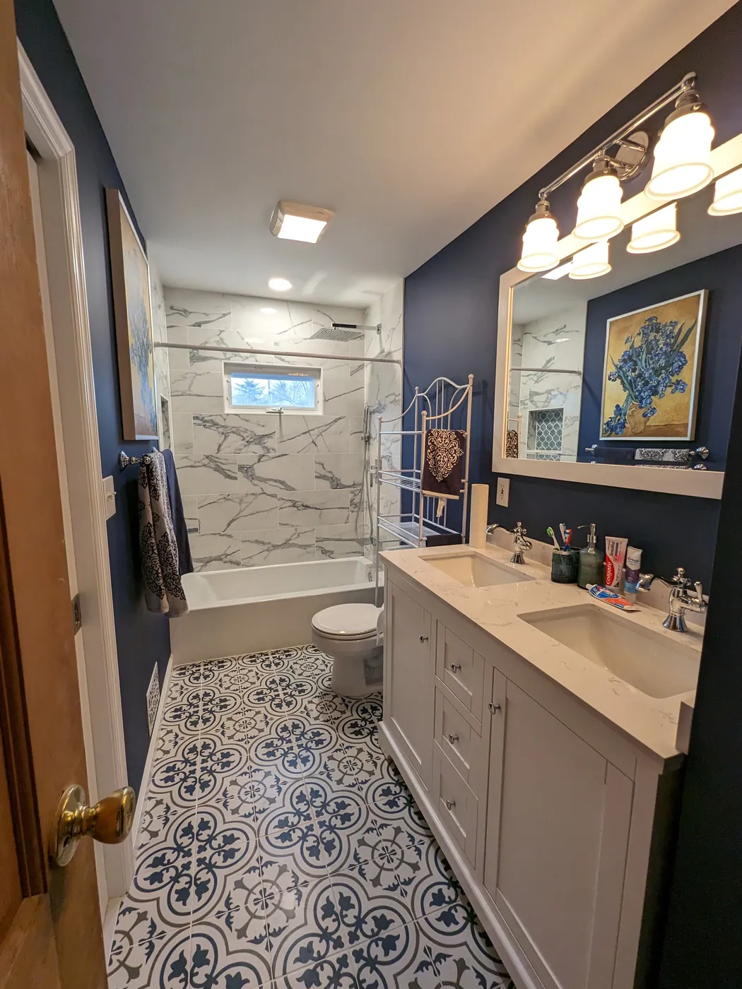 Remodeled bathroom with a double vanity and patterned tile