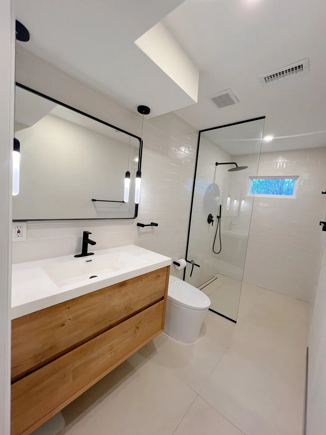 Remodeled bathroom with a glass-panel shower and a floating vanity