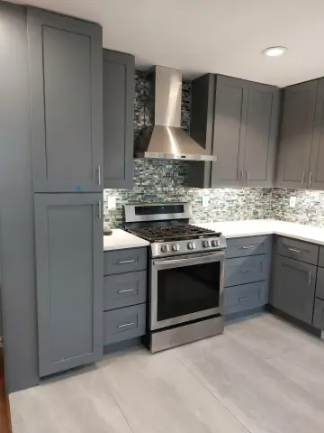 Gray shaker kitchen with stainless range hood